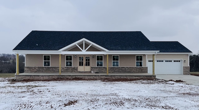 view of front of home with covered porch, a garage, and french doors