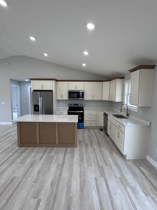 kitchen with a center island, light hardwood / wood-style floors, and lofted ceiling