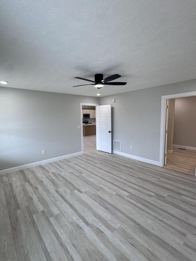 interior space with light hardwood / wood-style flooring and a textured ceiling