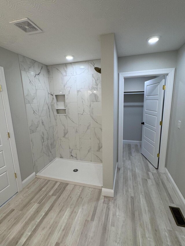 unfurnished bedroom featuring light wood-type flooring, a textured ceiling, and a closet