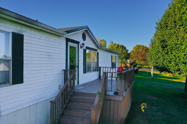 view of side of home featuring a wooden deck and a lawn