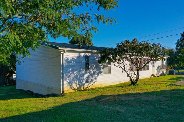 view of side of home featuring a yard and cooling unit