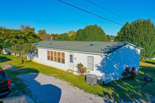 back of house featuring central AC and a yard