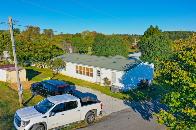 view of front of house featuring a front yard and central AC unit