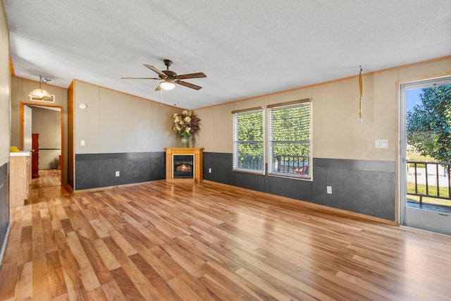 unfurnished living room featuring a textured ceiling, light hardwood / wood-style floors, and ceiling fan