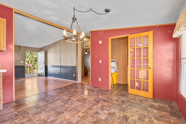 interior space with lofted ceiling, dark hardwood / wood-style floors, a chandelier, and a textured ceiling