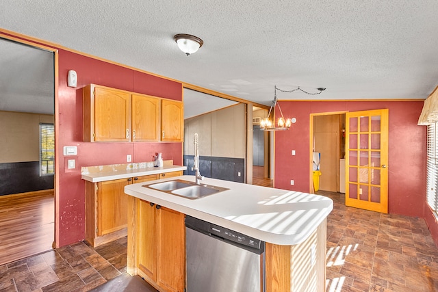 kitchen with an island with sink, a textured ceiling, vaulted ceiling, dishwasher, and decorative light fixtures