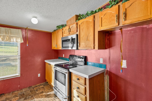 kitchen featuring appliances with stainless steel finishes and a textured ceiling