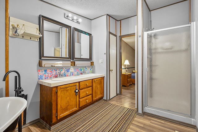 bathroom with decorative backsplash, a textured ceiling, wood-type flooring, vanity, and plus walk in shower