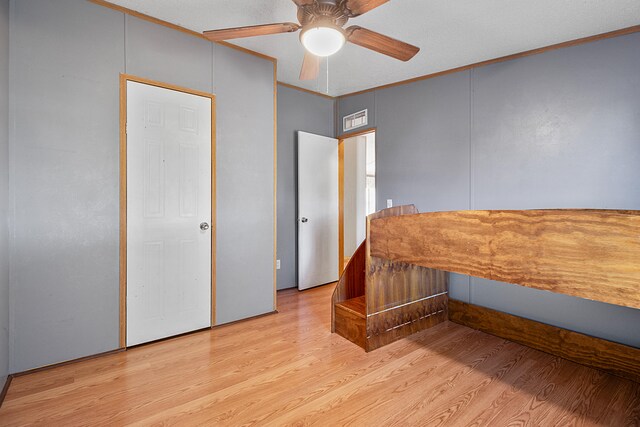 bedroom with ornamental molding, light wood-type flooring, and ceiling fan