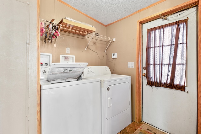 clothes washing area with ornamental molding, a textured ceiling, and washer and clothes dryer