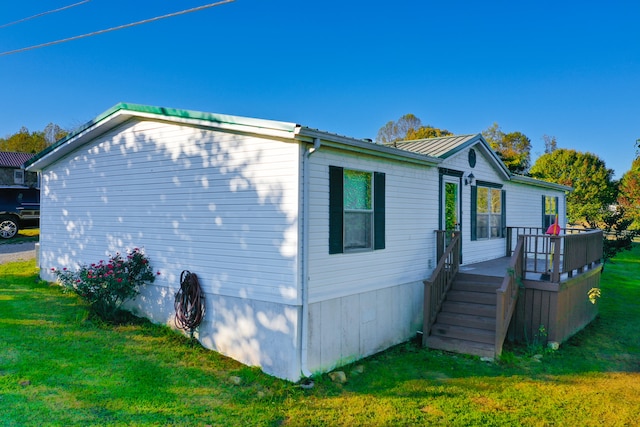 view of side of home featuring a yard and a deck