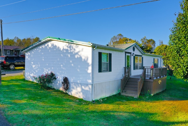 view of property exterior with a wooden deck and a lawn