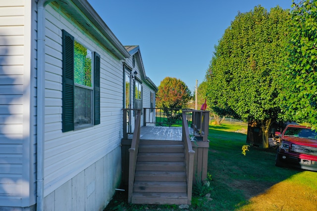 view of property exterior featuring a yard and a wooden deck