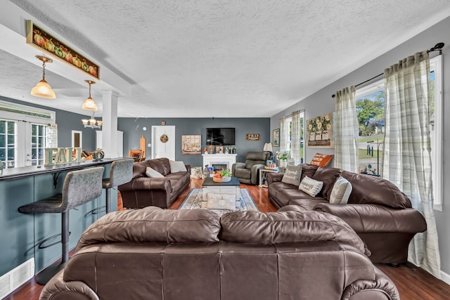 living room featuring dark hardwood / wood-style floors, a chandelier, and a textured ceiling