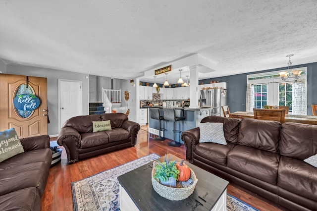 living room featuring a notable chandelier, a textured ceiling, and dark hardwood / wood-style flooring