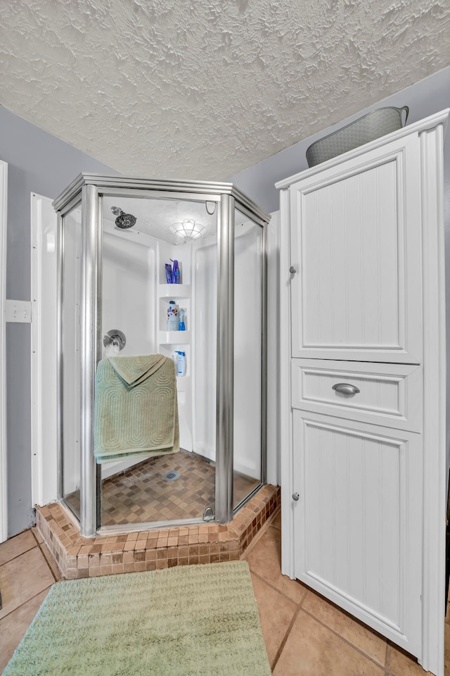 bathroom featuring an enclosed shower, a textured ceiling, and tile patterned flooring