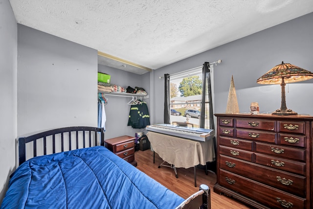 bedroom featuring a textured ceiling and light wood-type flooring