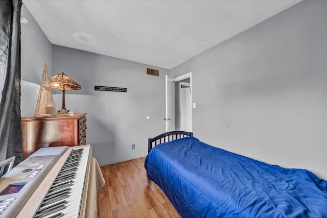 bedroom featuring a textured ceiling and light wood-type flooring