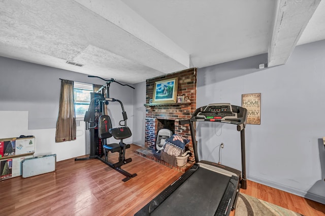 exercise room with a textured ceiling and wood-type flooring