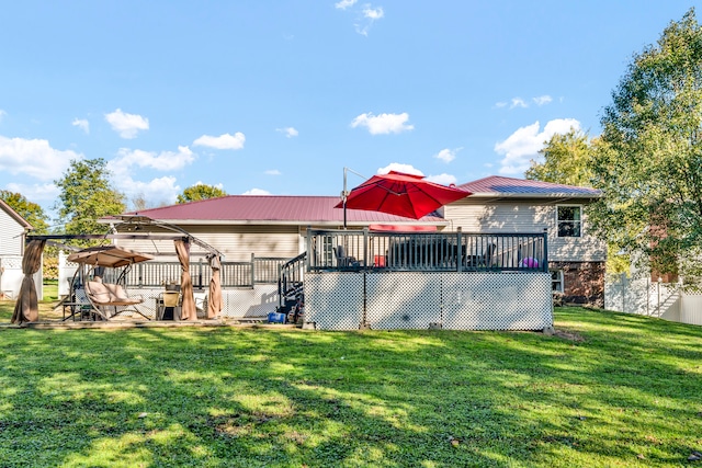 rear view of property with a wooden deck and a lawn