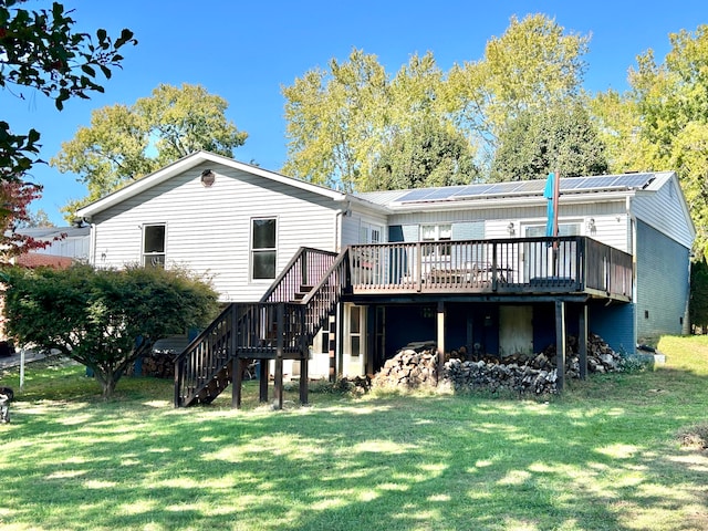 rear view of house featuring a wooden deck and a lawn