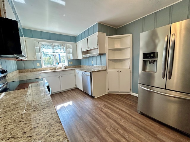 kitchen featuring white cabinets, light stone counters, sink, light hardwood / wood-style floors, and stainless steel appliances