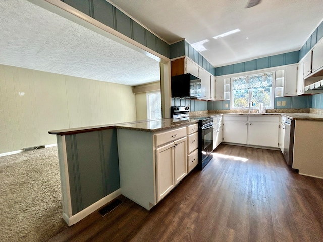 kitchen with black appliances, white cabinets, and dark hardwood / wood-style floors