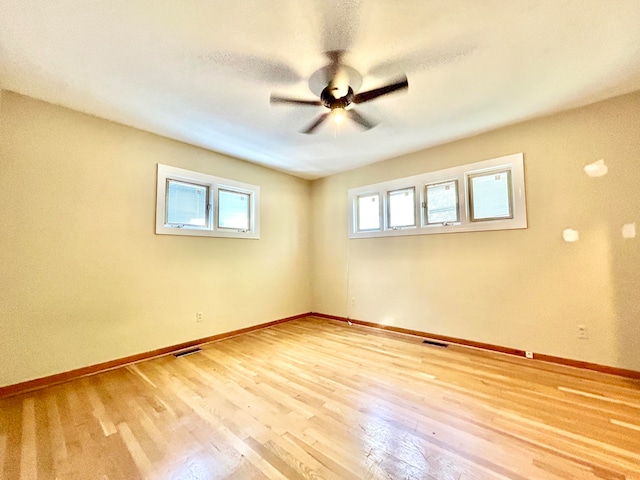 spare room with light wood-type flooring and ceiling fan