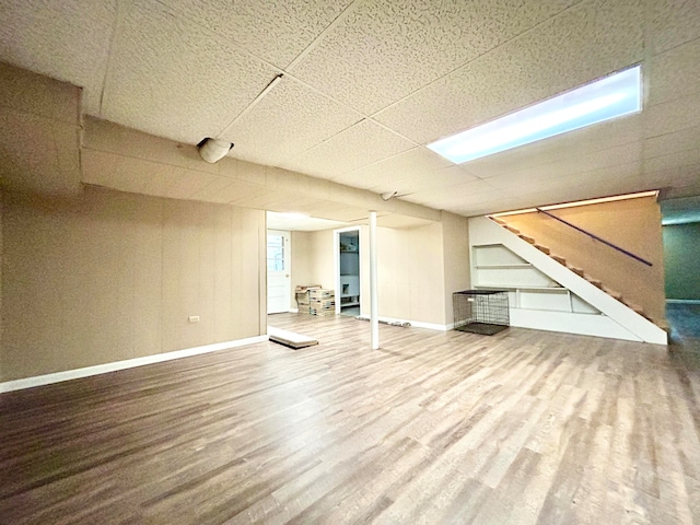 basement featuring hardwood / wood-style flooring and a drop ceiling