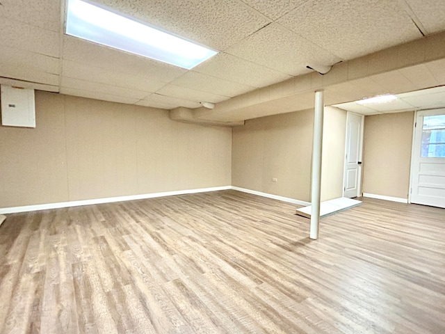 basement featuring a paneled ceiling and wood-type flooring