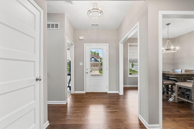 foyer with a notable chandelier and dark hardwood / wood-style flooring