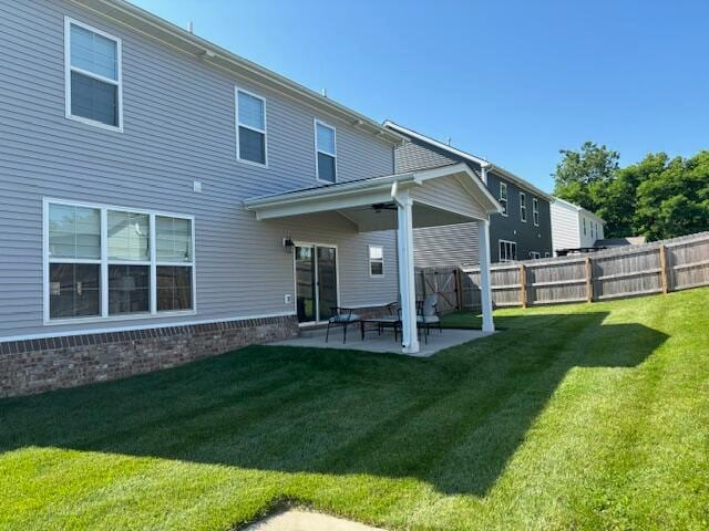 rear view of property featuring a patio, ceiling fan, and a lawn