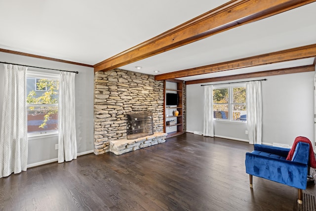 unfurnished room featuring a stone fireplace, ornamental molding, a healthy amount of sunlight, and dark wood-type flooring