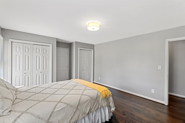 bedroom with dark wood-type flooring and multiple closets