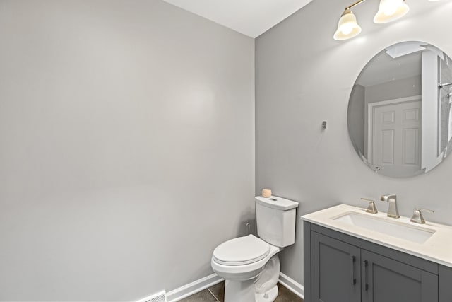 bathroom featuring toilet, vanity, and tile patterned flooring