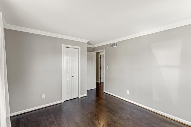 empty room with ornamental molding and dark hardwood / wood-style flooring