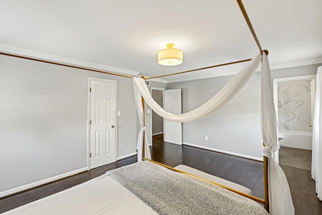 bedroom with connected bathroom, ornamental molding, and dark hardwood / wood-style flooring