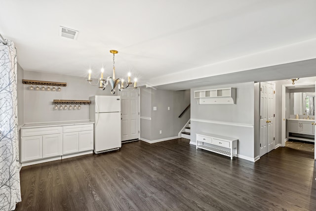 unfurnished dining area featuring a notable chandelier and dark hardwood / wood-style flooring