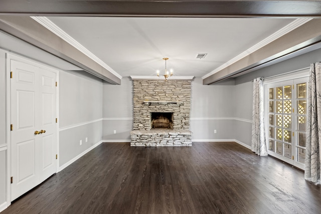 unfurnished living room featuring a stone fireplace, a notable chandelier, ornamental molding, and dark hardwood / wood-style flooring