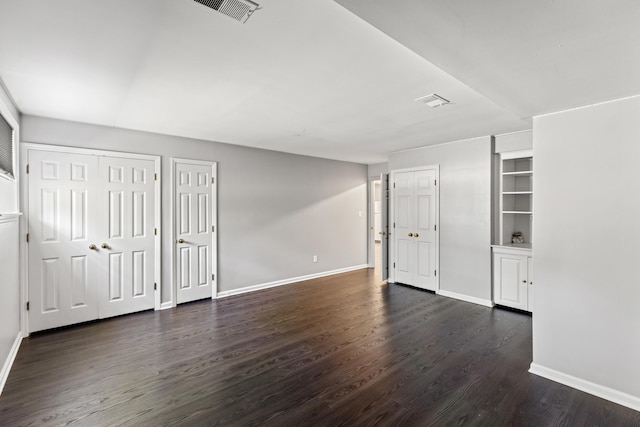 interior space with two closets and dark hardwood / wood-style flooring