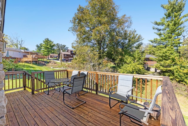 wooden deck featuring a lawn