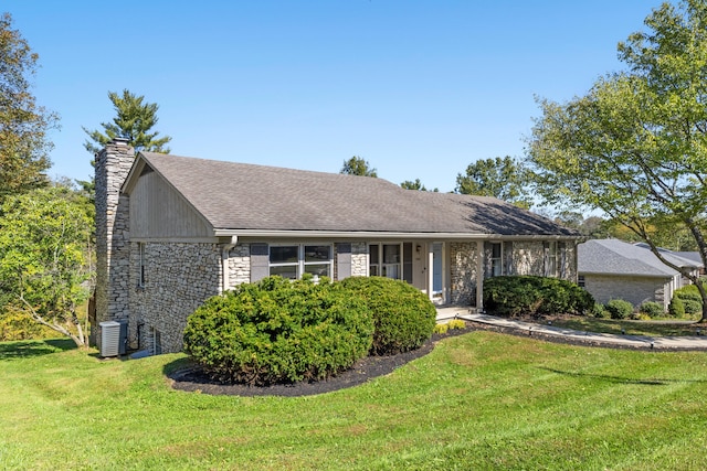 ranch-style home featuring a front lawn and central AC unit