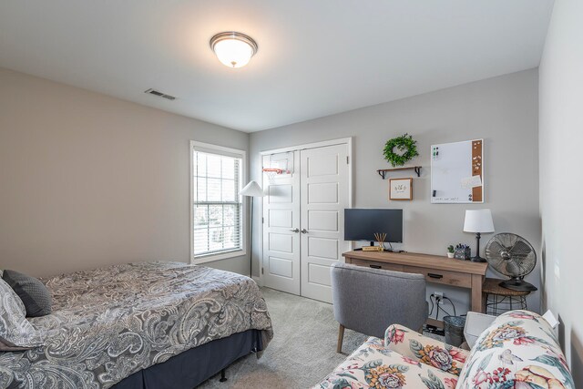 bedroom with light carpet and a closet