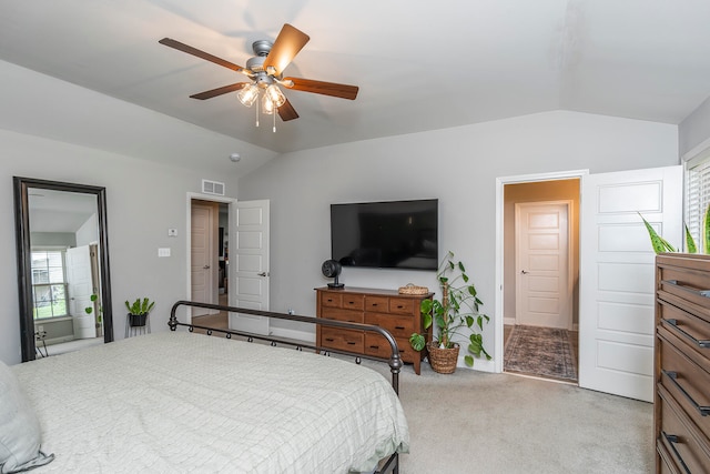 carpeted bedroom with connected bathroom, ceiling fan, and lofted ceiling