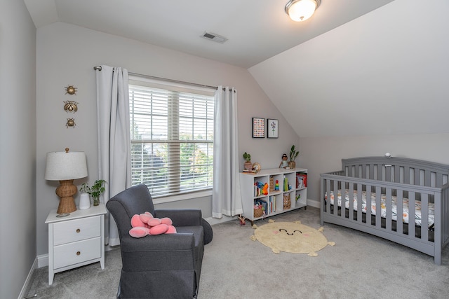 carpeted bedroom featuring vaulted ceiling and a nursery area