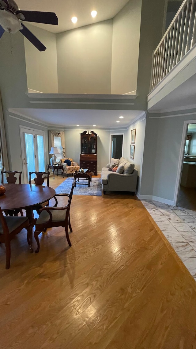 interior space featuring a high ceiling, hardwood / wood-style flooring, and ceiling fan