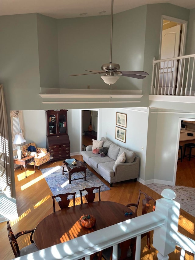 living room featuring light hardwood / wood-style floors, high vaulted ceiling, and ceiling fan