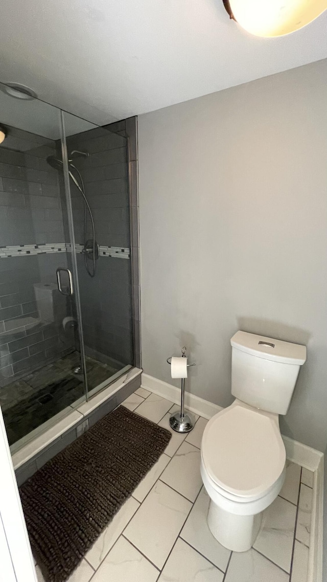 bathroom featuring tile patterned flooring, toilet, and walk in shower