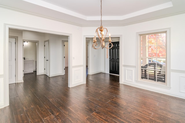 unfurnished dining area featuring crown molding, dark hardwood / wood-style floors, and a tray ceiling